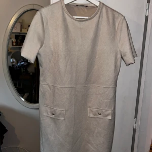 Beige klänning med detaljer - Storlek: M Använd: 1-3 gånger