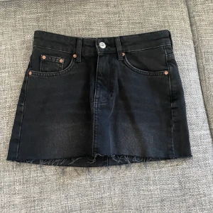 Svart jeanskjol - Svart kort jeanskjol från Gina tricot. Storlek 32. Köptes i slutet av förra sommarn och är nu för liten så inte använd så mycket❣️hör av er för fler bilder. köparen står för frakten! 