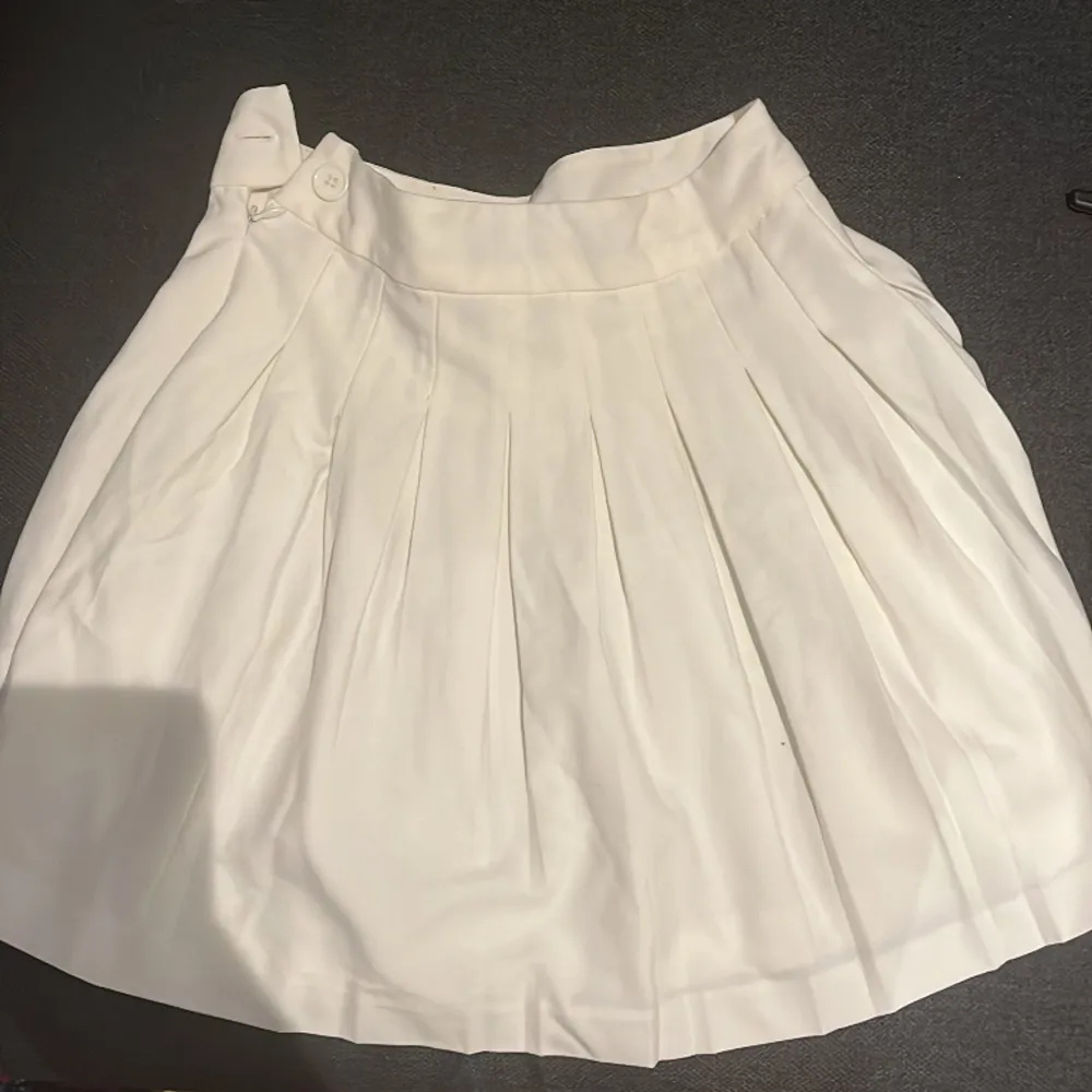 Säljer denna vita kjolen pga att det inte är min stil och lite för stor för mig. Man kan knäppa vid sidan. Midjan är ca 32cm och längden på kjolen är 39/38. Kjolen är lite lågmidjad. Perfekt för sommaren och man kan styla den på många sätt. Köp!💞❤️. Kjolar.