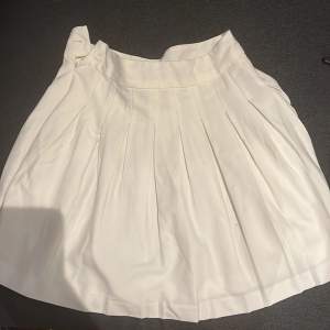 Säljer denna vita kjolen pga att det inte är min stil och lite för stor för mig. Man kan knäppa vid sidan. Midjan är ca 32cm och längden på kjolen är 39/38. Kjolen är lite lågmidjad. Perfekt för sommaren och man kan styla den på många sätt. Köp!💞❤️