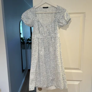 Brandy Melville klänning - Supersöt brandy Melville klänning med blommor och knyte i ryggen. Storlek Xs, passar även S. Använd 1 gång, nyskick. 