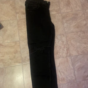 Zara jeans - Svarta mig waist Zara jeans med slitningar på knäna i storlek 44, blivit för stora för mig och byxorna säljs för 130 kr