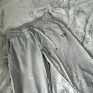 Ett par ea7 mjukis i ljusgrå färg. Inget fel på byxorna endast att de finns fläckar på dem. 