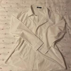 En enkel vit skjorta från shein i storlek S, lent mattial och är inte super genomskinlig!