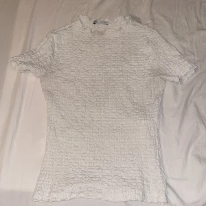 Zara tröja - Säljer denna jätte populära trendiga vita räfflade toppen från zara med jätte gulliga detaljer!!💗 Har ej hittat användning och har liknande, inga synliga defekter❣️Storlek s men sitter som XS lika bra