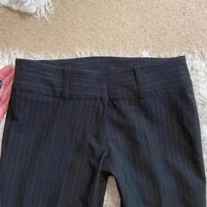 Lågmidjade kostymbyxor  - Lågmidjade pinstriped kostymbyxor men utsvängda ben. Står att de är 34 men snarare 36. Stretchiga. Skriv i dm för fler bilder och mått.