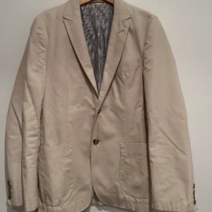 Beige Kavaj  - Härlig beige kavaj, fåtal gånger använd. Fin färg som passar till allt. En avslappnad kavaj med mycket design.