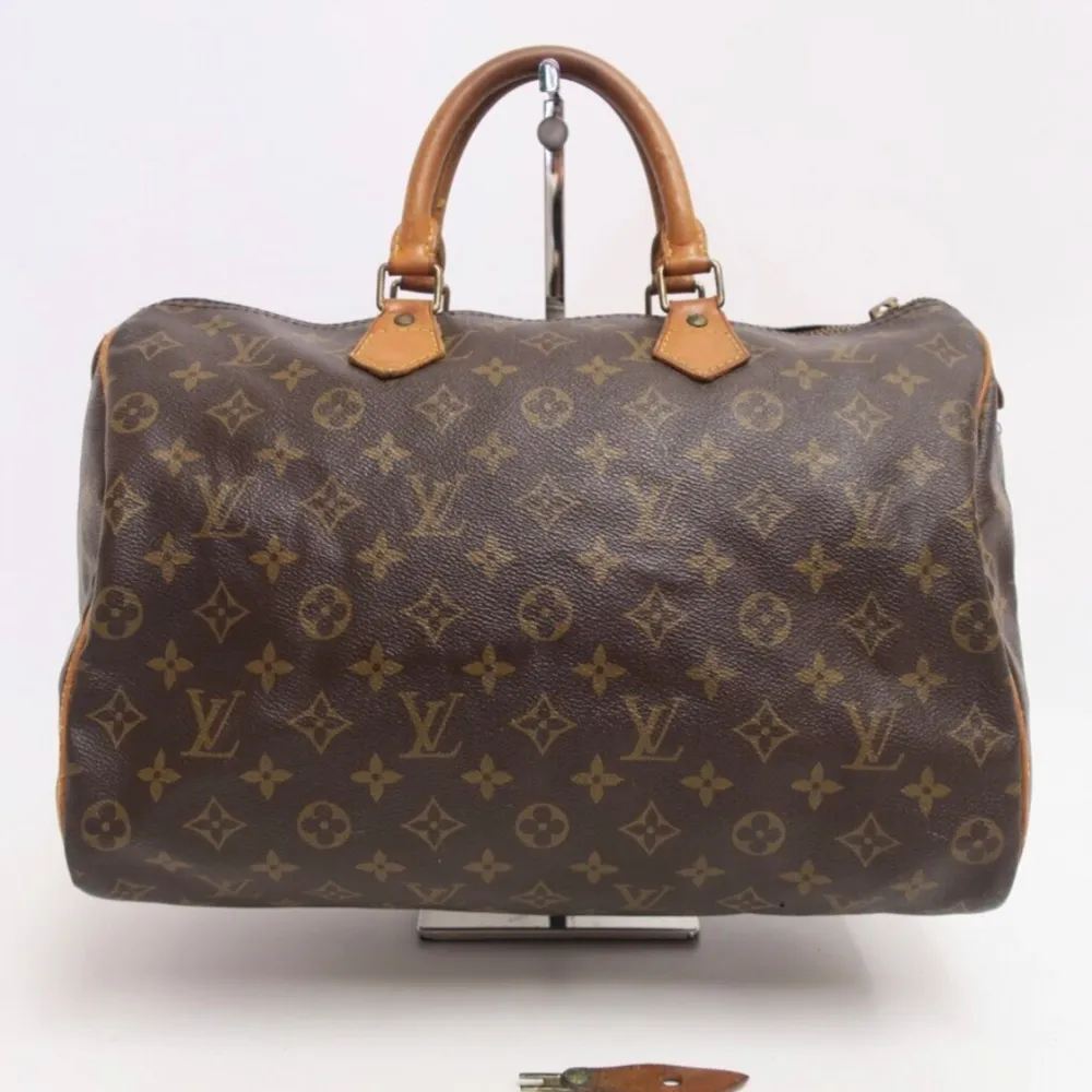 Louis Vuitton Speedy 35 är en tidlös klassiker! Det kommer att lägga till lyxig stil till alla kläder och passa alla tillfällen. Fler bilder och mer info i vår webbutik vintagetreasures.co. Väskor.