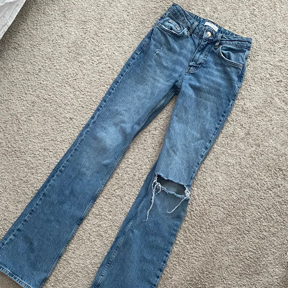 Ett par blåa bootcut jeans från Ginatricot. Sitter midwaist på mig. De är i ganska bra skick. Stl 32 men skulle säga att de passar storlek 34 också. Midjemått: 64 cm, innerbenslängd: 83 cm. Pris kan diskuteras! . Jeans & Byxor.