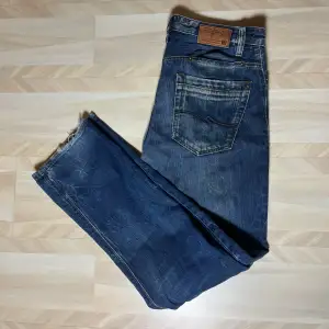 Jack & Jones jeans i bra skick (8/10) lite slitna längds ner på benen. Vårat pris är 249kr. Storlek 31/34.Tveka inte att höra av dig vid eventuella frågor!😊
