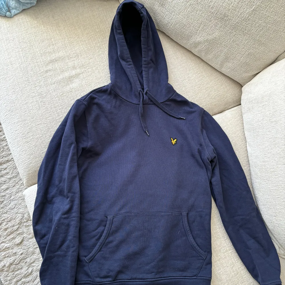 Marinblå Lyle & Scott Hoodie i bra skick. Inga defekter eller fläckar.  Köpt på herr, men fungerar unisex.  Herr: S Dam: M. Hoodies.