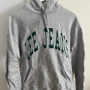 Superfin grå hoodie med grönt tryck från Lee Jeans! Använd få gånger så i mycket fint skick. Nypris ligger på 799kr.
