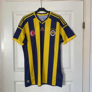 Fenerbahce 2014/15 Hemmatröja - Turkiska laget Fenerbahces hemmatröja från säsongen 2014/15. Tröjan är i toppskick! OBS! Tröjan är inte autentisk/äkta! Tveka inte att kontakta mig vid frågor eller funderingar.