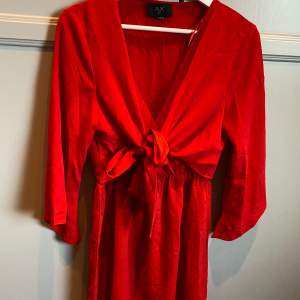 Röd klänning från AX PARIS  Helt ny- aldrig använd  Rosett som man kan knyta som man vill! Storlek 40/M  Nypris 599kr Rök och djurfritt hem! 