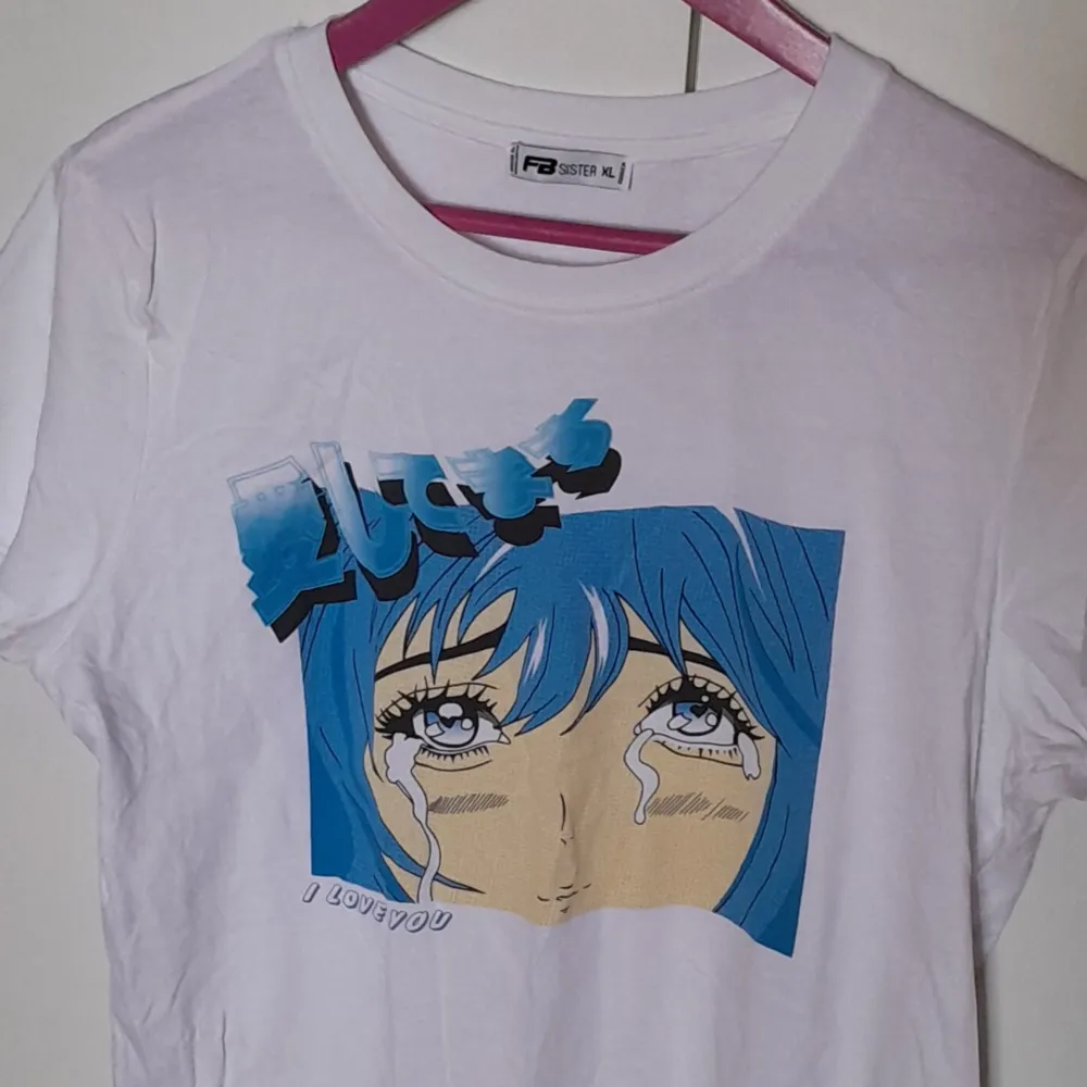 En vit t-shirt med blått anime-tryck.. T-shirts.