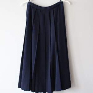Marinblå/mörkblå kjol plisserad. Inget märke eller storlek men skulle säga att den är runt S. Midja (tvärs över): 32 x 2 Längd: 73 cm. 