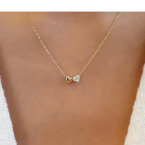 Double heart- halsband oöppnad - Helt ny Dubbelhjärta halsband. Stilfull som passar alla outfits. 18 karat guldpläterad och material av högsta kvalitet. Vattentålig, rostar inte. Perfekt present.