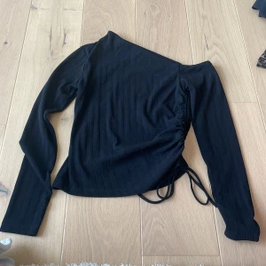 Topp gina - Topp med jätte fin halsringning, visar ena axeln. 