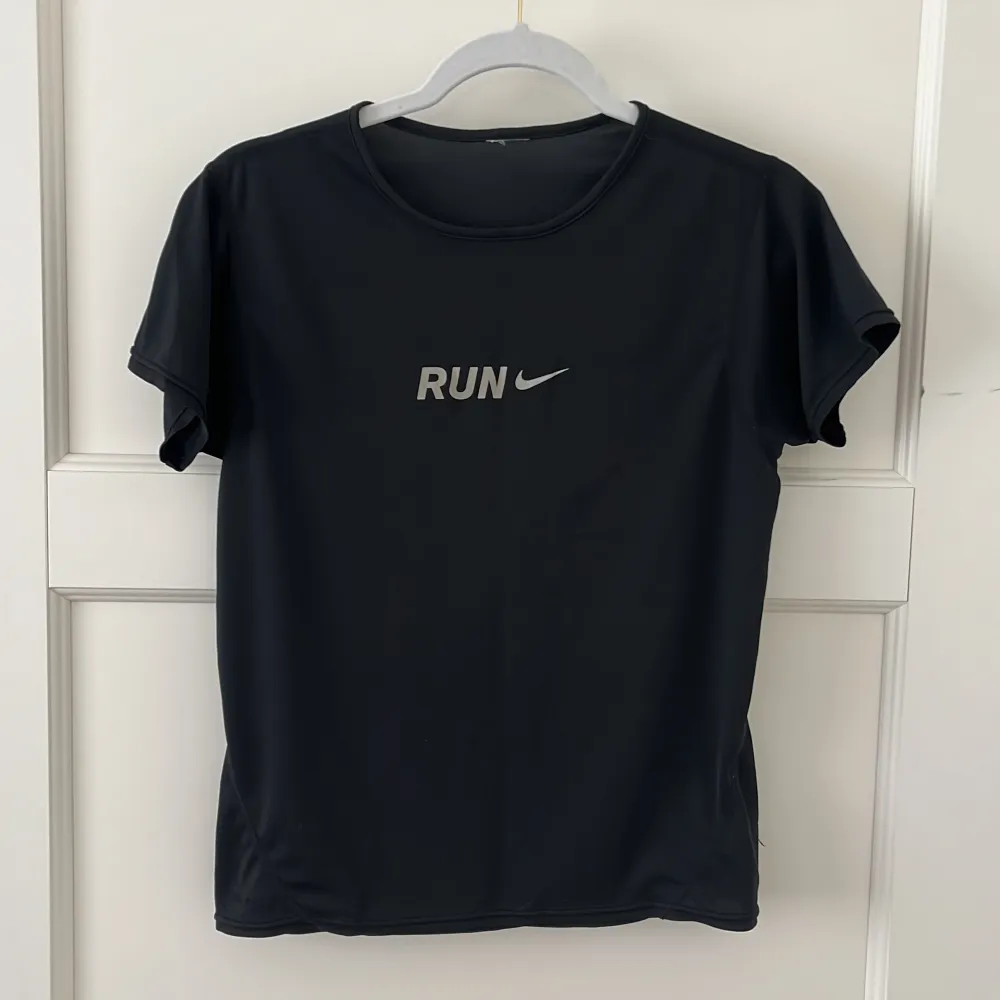 Svart Nike t-shirt för träning med texten RUN i reflex. Denna kan du springa snabbt i! Väldigt tunnt och behagligt material och i storlek som passar XS och S skulle jag säga. . Sportswear.