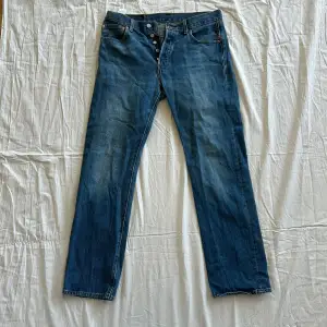 Har använts 10-tal gånger men har inga skador. Klassiska blå 501 Levi’s Jeans. Storlek: W 32, L 32. Tvätt: 30 grader. 100% Cotton/Bomull