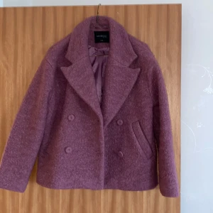 Stickad kort vår/vinter jacka  - Helt ny mörk rosa vår/vinter jacka med 2 knappar på varsin sida och fickor, kanske använd 1-2 gånger några år sen men helt nytt skick inget trasigt 😊