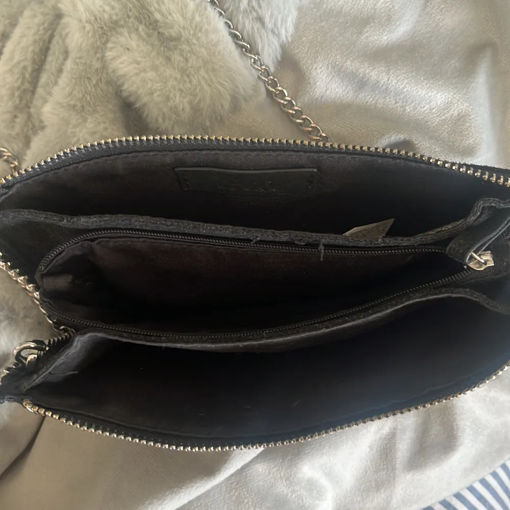 Säljer min trendiga axelremsväska från Zara! Den är svart och skimrar lite i solen😍 Kommer inte till användning, nyskick använd fåtal ggr . Väskor.