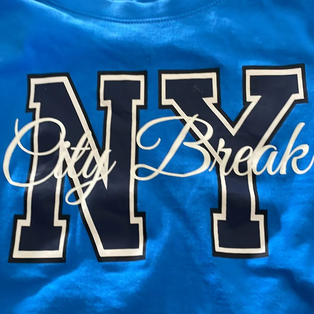 En blå T-shirt som det står NY city break på. Den är använd några fåtal gånger och är i väldigt bra skick. Storlek 146/157  . T-shirts.