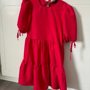 Klänning med rosetter - Säljer denna klänning med rosetter i antigen ryggen eller om man vill ha det fram! Knyten på armarna också❤️