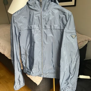 Prada Nylon Windbreaker - Prada windbreaker i storlek 48. Väldigt små fläckar bak på armen och höger axel/bröst som knappt syns i dagsljus, därav billigt pris. Annars väldigt bra skick. Priset kan diskuteras.