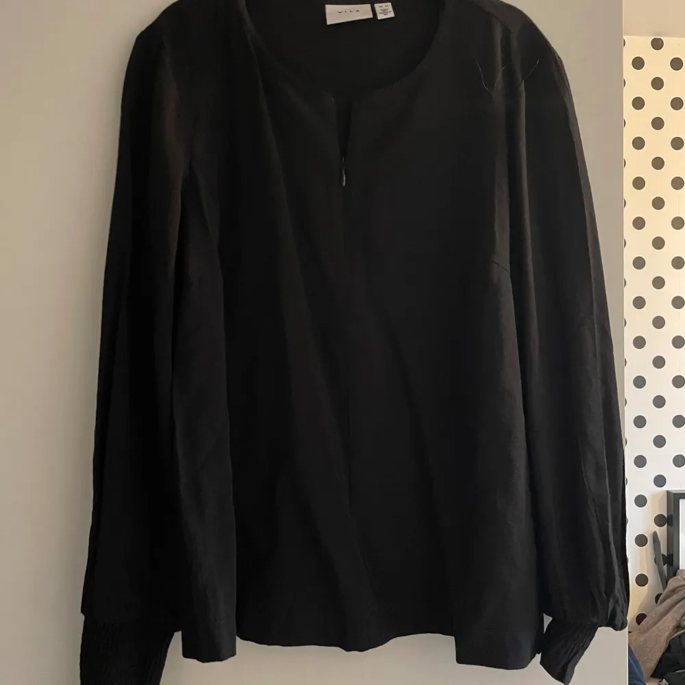 Svart elegant blus från vila i nyskick. Med dragkedja som går att dra ända upp . Puserot.