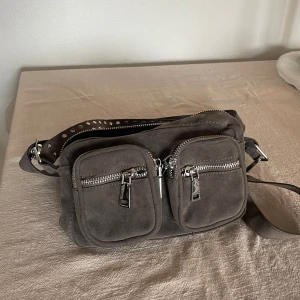 Noella väska - Noella väska bred: 25 cm och höjd: 15 cm  Helt oanvänd!! Säljer pga inte min stil. Ordinarie pris 799kr
