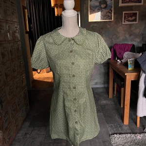 Klänning - Jättefin grön klänning med mönster och krage. Köpt från cider. Använd ett fåtal gånger. Den är som ny