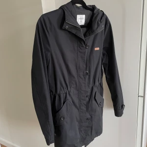 Jacka  - Tunnare jacka med resor i midjan. 