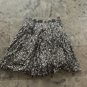 Kjol zara - Kjol från zara i väldigt svart kjol med beige/vita blommor på i bra skick. Har bara använts 1 gång och inte slitits. Kjolen har shorts i sydda 