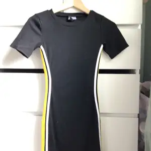 Svart tight klänning med gula och vita ränder på sidorna från h&m