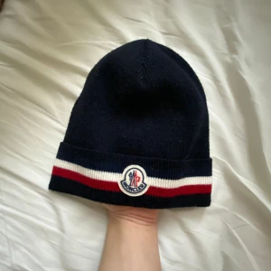 Moncler mössa - En fräsch moncler mössa som jag tänkt sälja pågrund av att jag inte har någon användning av den! Skick 9/10. Nypris: 2225 kr. Mitt pris 1000 kr!