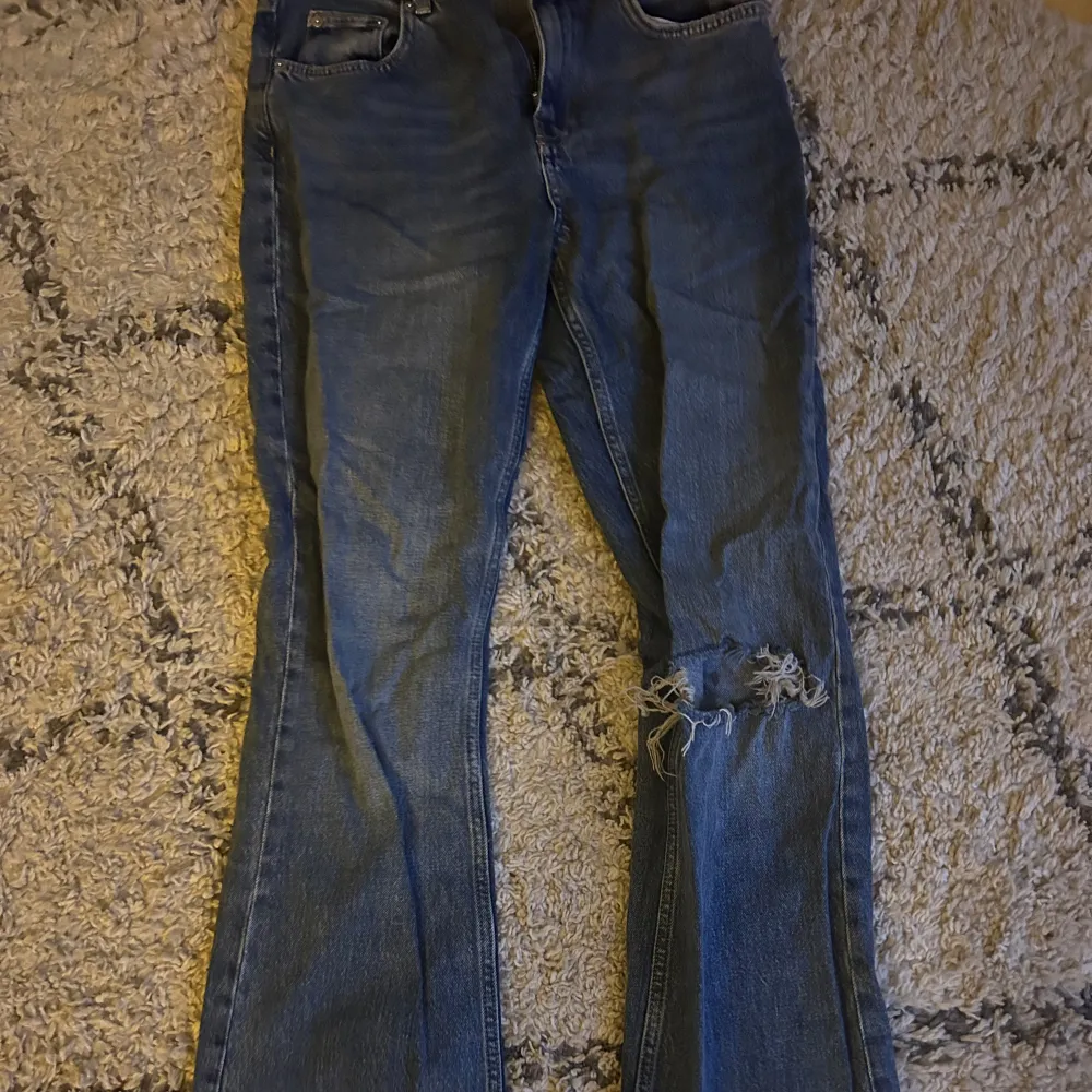 Supersnygga blå jeans från gina som inte längre kommer till användning. De är mid waist och har hål på högra knät. Skriv om du har några frågor💖. Jeans & Byxor.