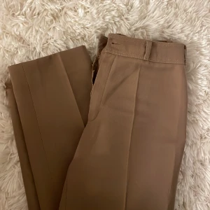 Kostymbyxor - får inte färgen rättvis på kameran men typ ljusbruna kostymbyxor köpta secondhand. Då dom är omsydda så skulle jag säga att de är XS. 
