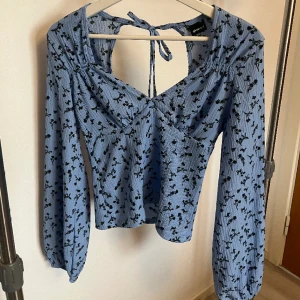 Blå blommig topp - Säljer denna söta topp med små blommor på från Ginatricot. Bara provat men aldrig använt då den var för liten. 
