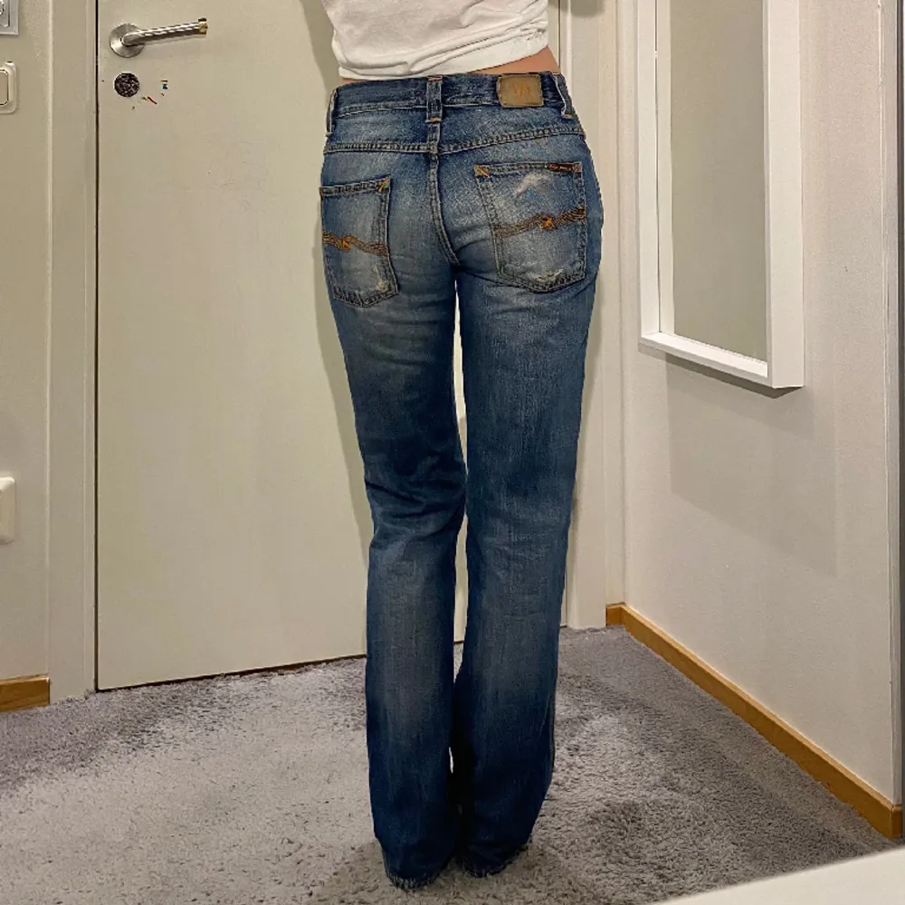 Straighta jeans från Nudie Jeans. Innerbenslängd: 79cm, midjemått (rakt över): 39cm. Lappen på baksidan har hårdnat (se bild tre) och jeansen har även flera slitningar. Jeans & Byxor.