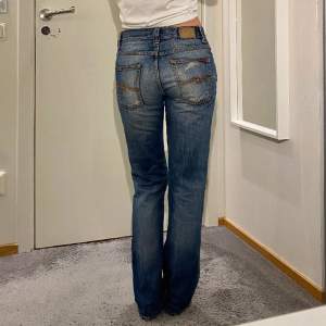 Straighta jeans från Nudie Jeans. Innerbenslängd: 79cm, midjemått (rakt över): 39cm. Lappen på baksidan har hårdnat (se bild tre) och jeansen har även flera slitningar