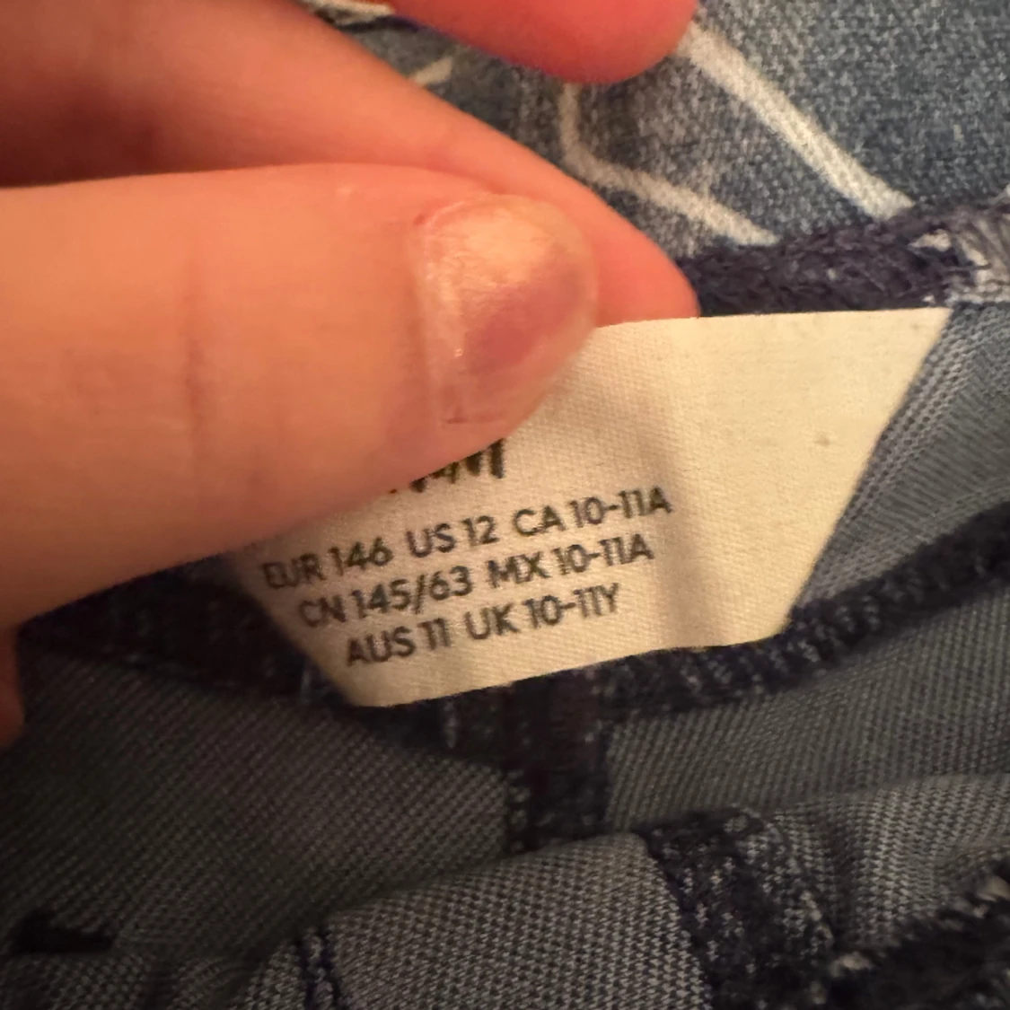 Ett par blåa jeans med smileys på  - 90