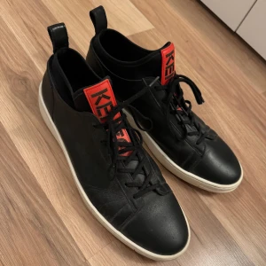 KENZO Skor - Skor från Kenzo. ”K-CITY BASKETS”. Storlek 45. True to size. (Jag har storlek 44 och en stor sula hjälpte) Köpta 2019 på Farfetch hemsida. Använda fåtal gånger. Tyvärr inget kvitto kvar! Box är kvar men har fått en fläck. Extra snören finns kvar. 