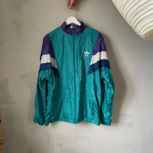 Vintage adidas windbreaker - Riktig retro adidasjacka. Inköpt second hand i Köpenhamn. Inga större defekter! Köparen står för frakten eller så finns den att hämta i södra sthlm! 😊