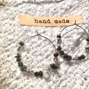 Örhängen - Handgjorda örhängen med stomme i silver och pärlor i svart, lila, silver och bergskristall. 