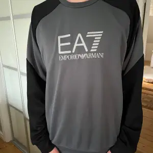 Långärmad EA7 tröja i färgen grå och svart. Nypris 1000kr. Väldigt bra skick och har aldrig blivit använd och har inga tecken på användning. Passar storleken M