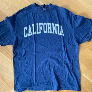 Mörkblå t-shirt med tryck California i strl xxs  Använd men i bra begagnat skick.  Kommer från ett djur och rökfritt.