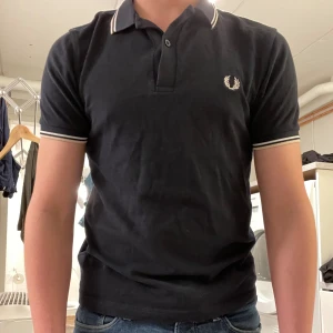 Fred Perry piké  - Säljer dena snygga piké då den inte kommer till användning. Skick 8/10 med en mindre defekt( Syns på sista bilden). färg är marinblå, vit och beige. pris kan diskuteras i dm.
