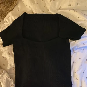 Ribbad tröja  - Svart ribbad kortärmad tröja, väldigt fin vid halsen/bröstet, aldrig använd, inga skador alls, vet tyvärr inte vart den kommer ifrån men väldigt stretchigt tyg, priset kan diskuteras 
