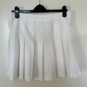 Vit veckad kjol/tenniskjol med gömd dragkedja på sidan